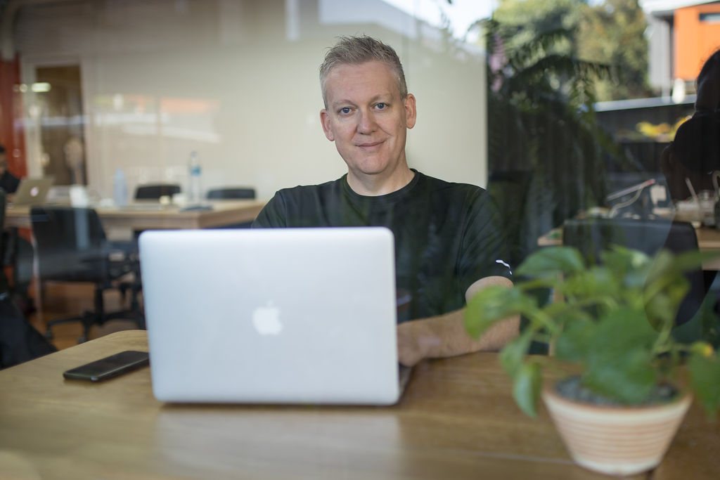 Stu Jordan working at his laptop in a cafe