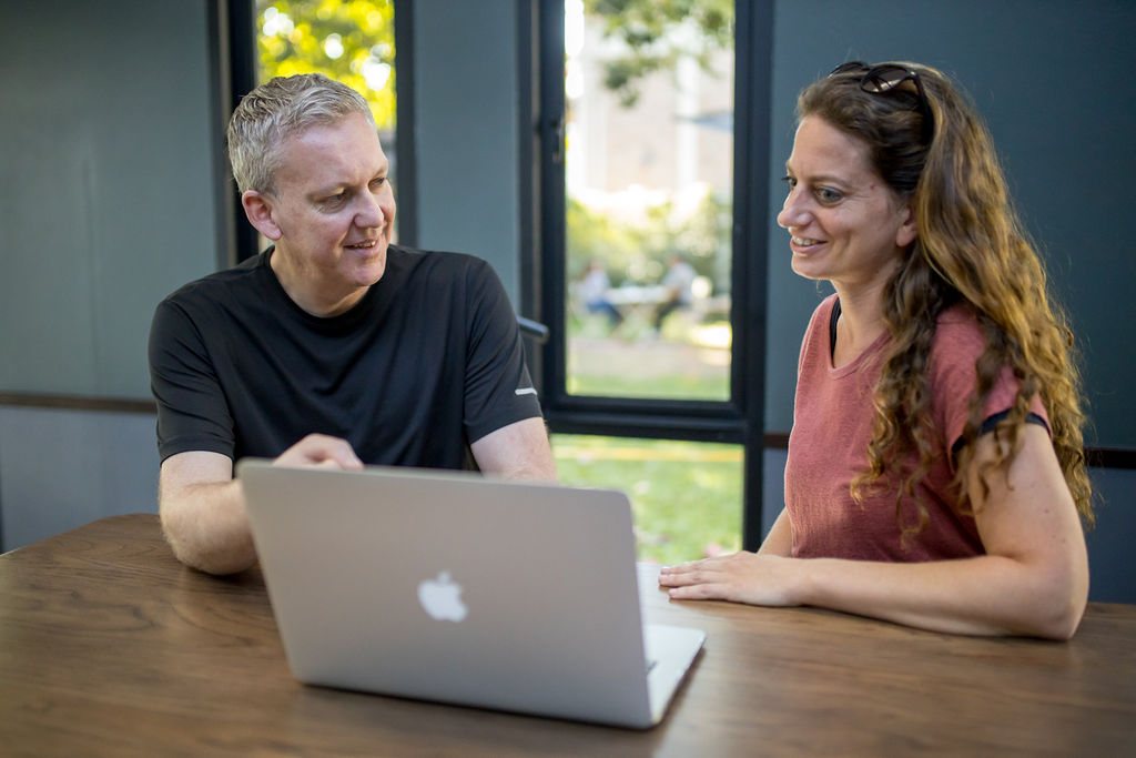 Stu Jordan at a table with a business owner, talking through something on a laptop
